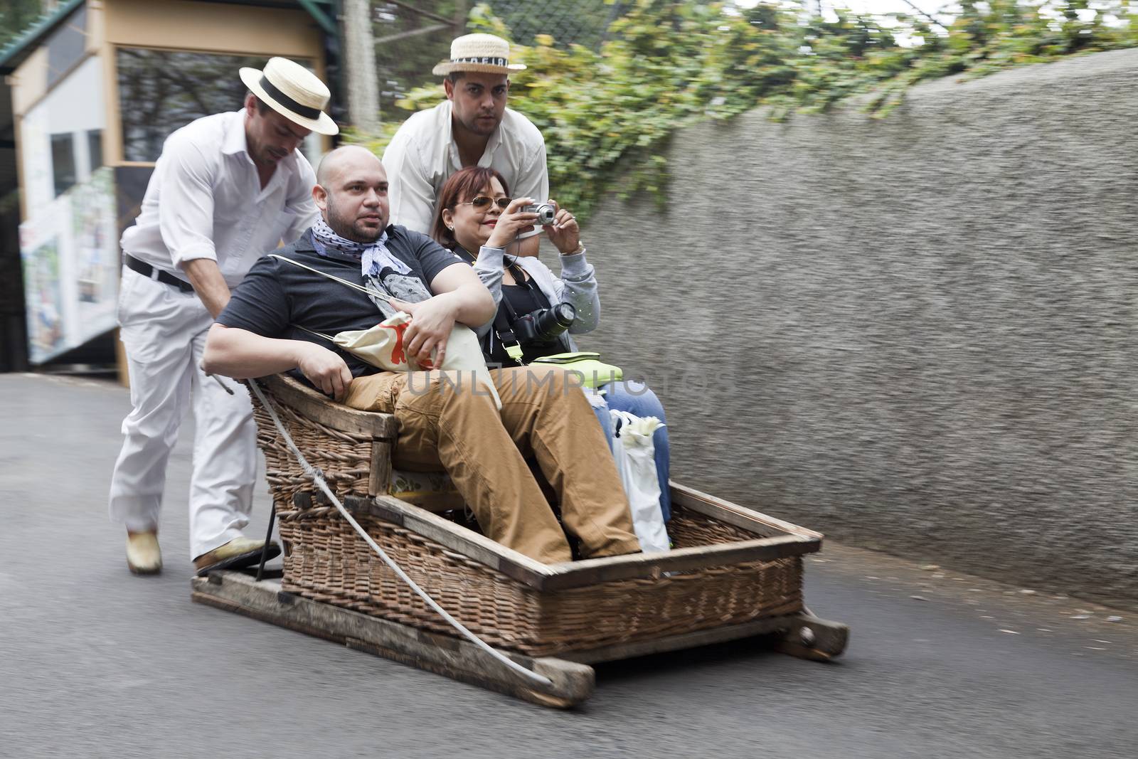 raditional downhill sledge trip on May 20, 2015 in Madeira, Portugal. Sledges were used as local transport. Currently these Toboggan riders are a touristic attraction by oleandra