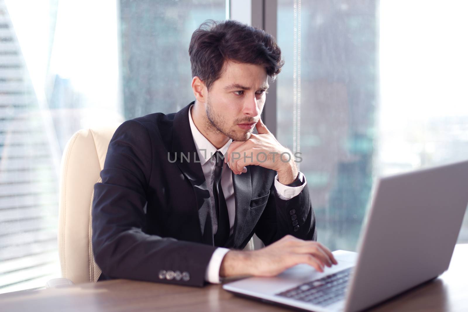 Busy businessman in office working on his laptop.