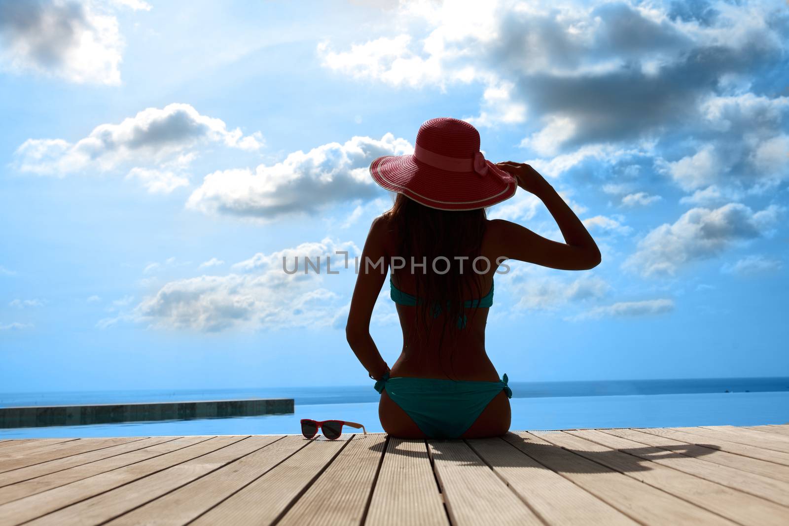 Beautiful woman relaxing by the pool at tourist resort