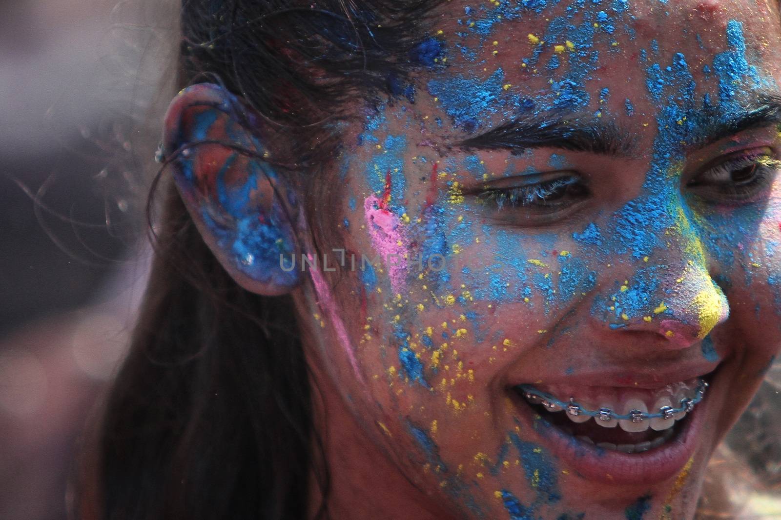MALAYSIA, Kuala Lumpur: A girl with her face colored by powder smiles as revellers dance and spray colored powder during the Holi Festival in Kuala Lumpur on March 26, 2016. Holi, also called the Festival of Colours, is a popular Hindu spring festival observed in India, Malaysia and other countries at the end of the winter season on the last full moon day of the lunar month. 