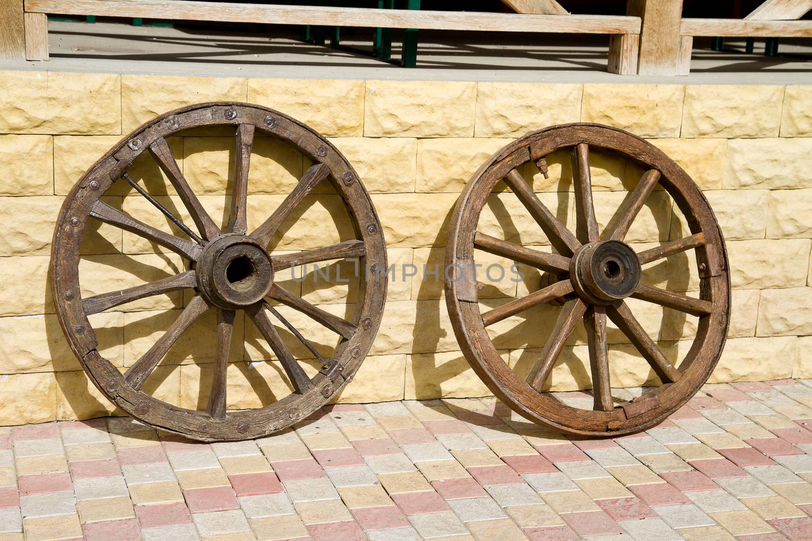 Wooden wheels of old carts hung on a wall.