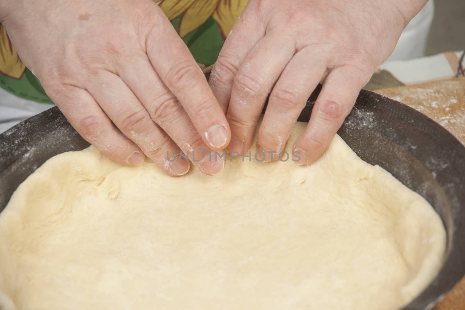 Making pie. Raw dough in black metal baking form