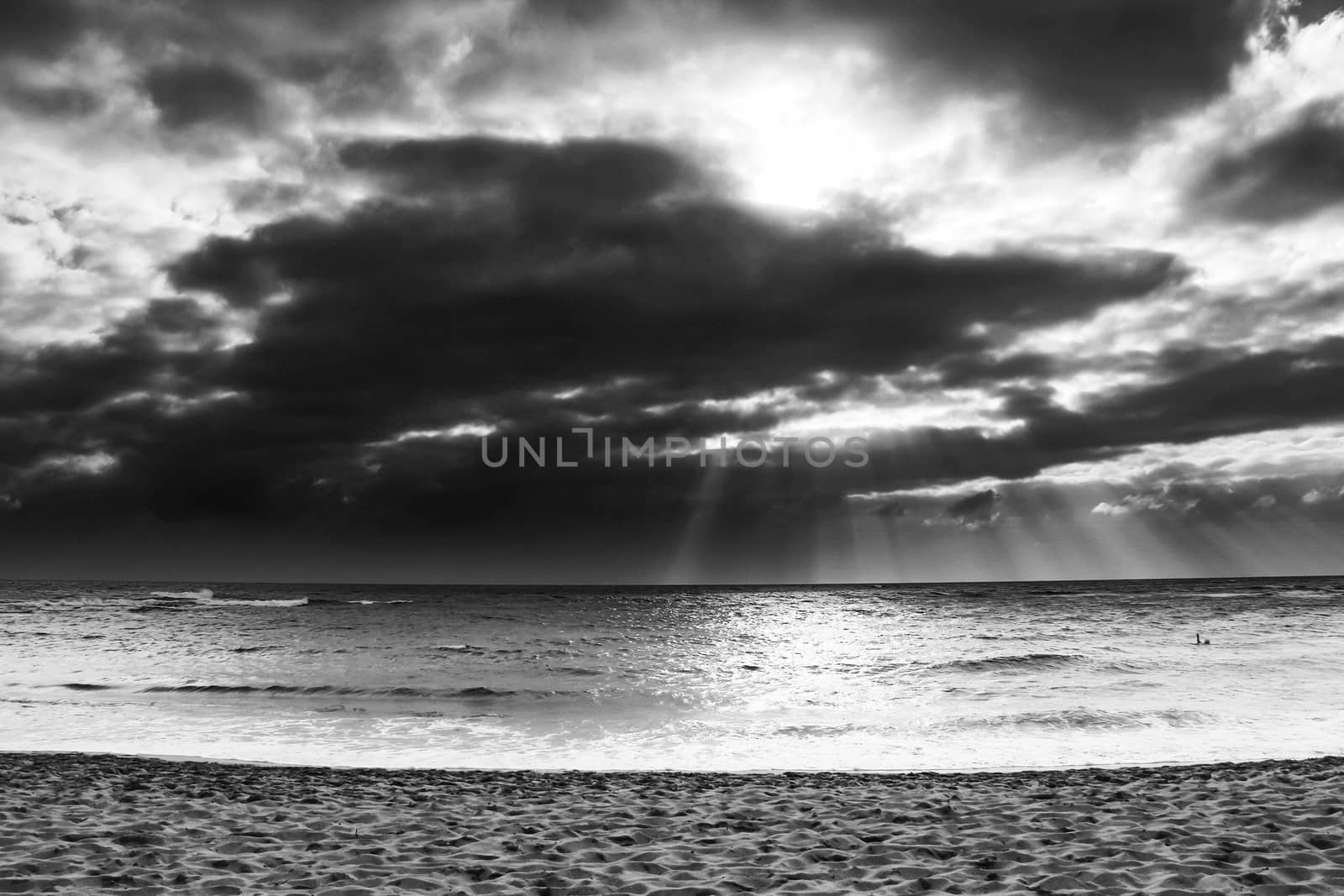 ray of sun over the beach at Kauai, Hawaii with cloudy sky in black and white by Timmi