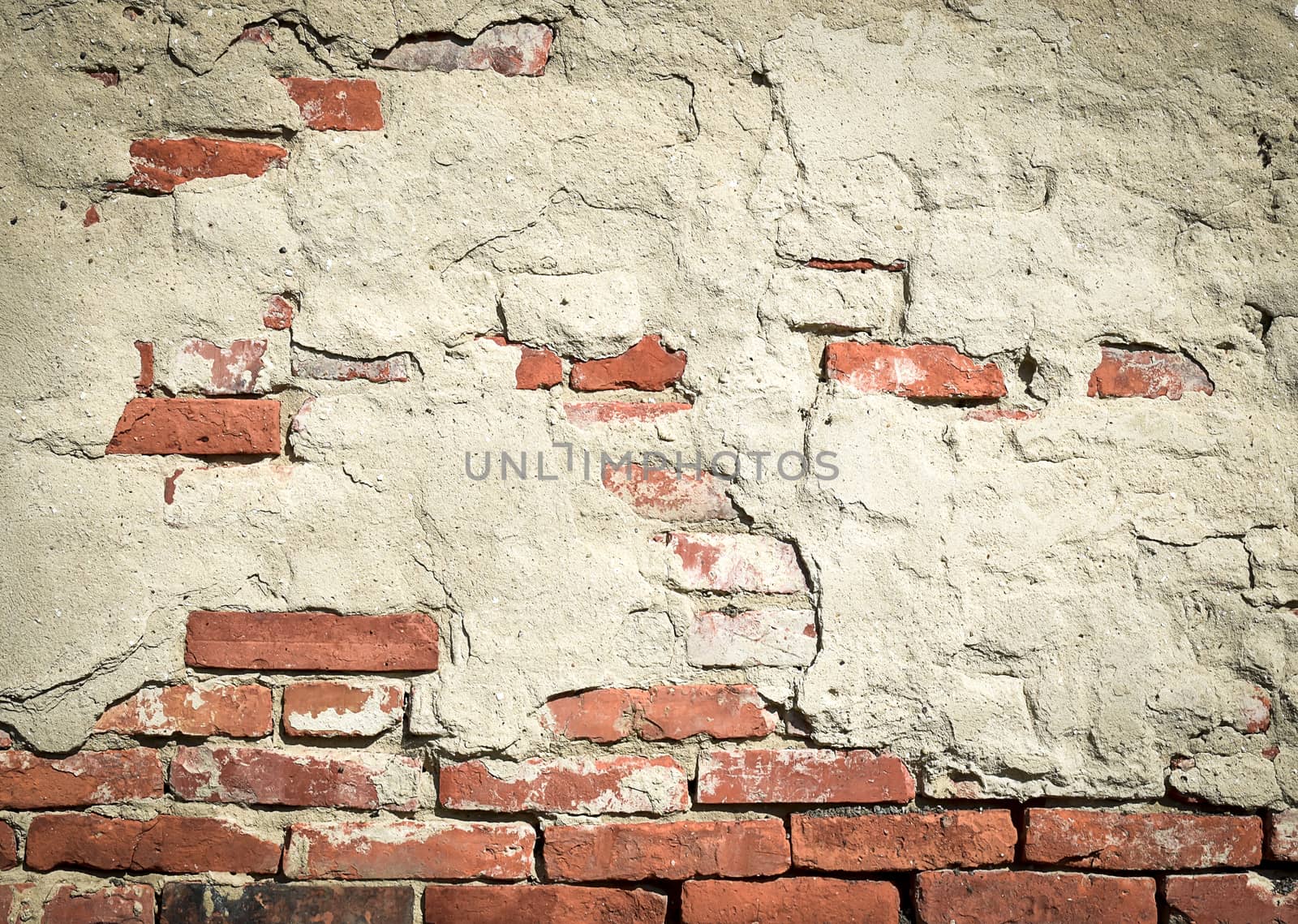 Old red brick wall with fallen plaster