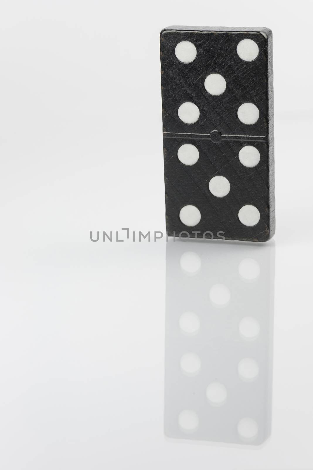 Standing black domino brick with white dots
