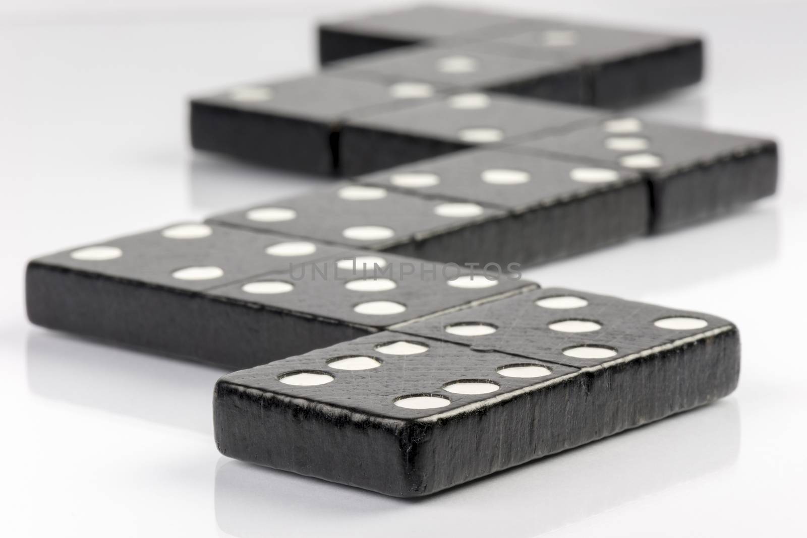 Composition of lying black domino bricks with white dots
