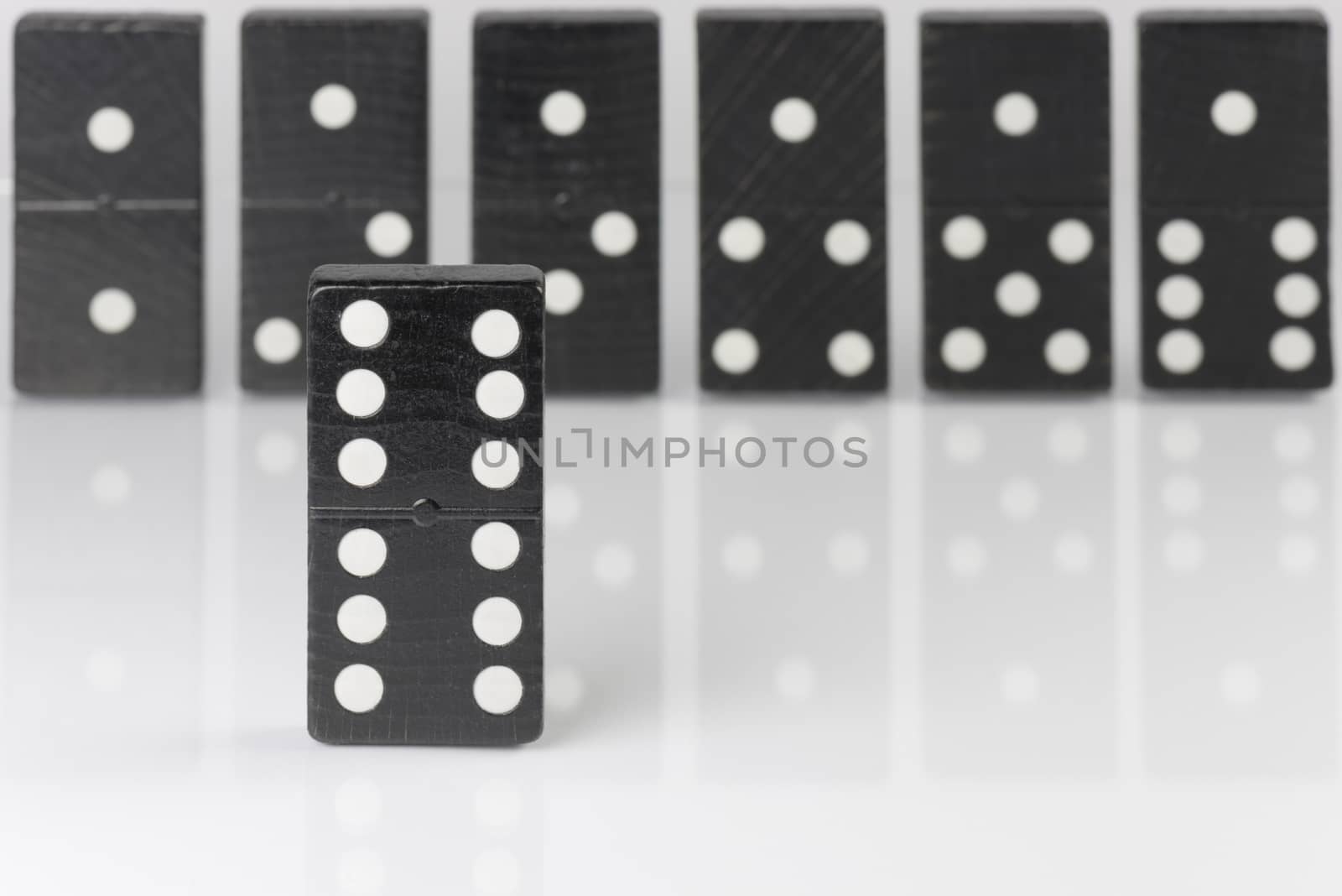 Composition of standing black domino bricks with white dots
