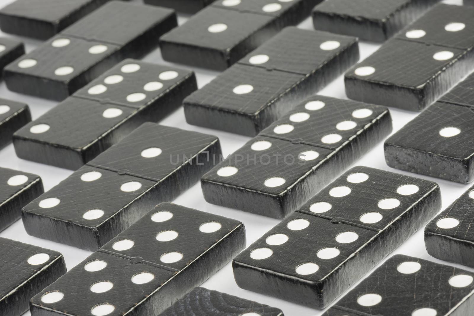 Composition of lying black domino bricks with white dots
