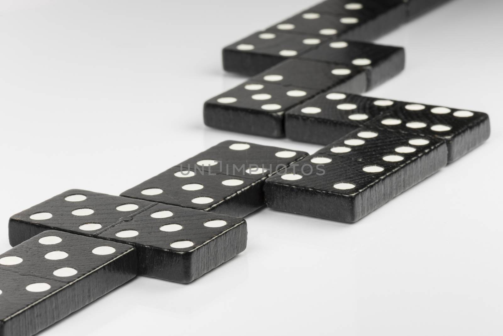 Composition of lying black domino bricks with white dots
