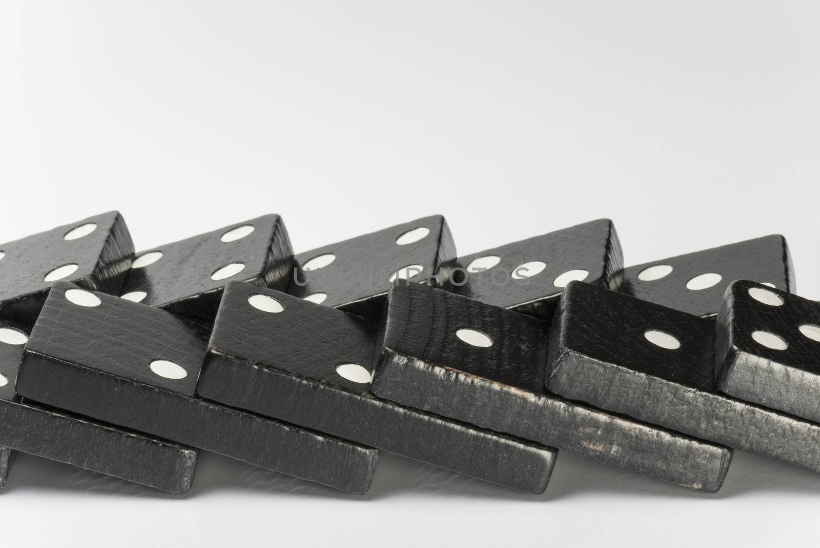 Composition of lying black domino bricks with white dots
