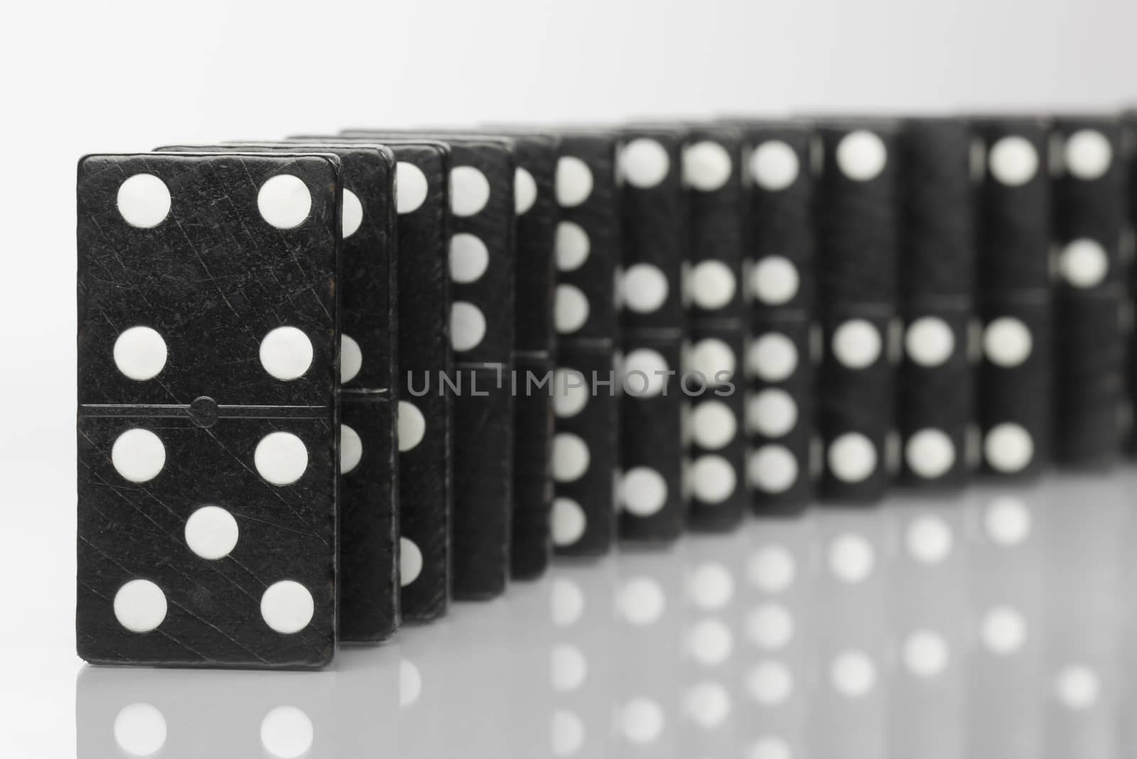 Composition of standing black domino bricks with white dots
