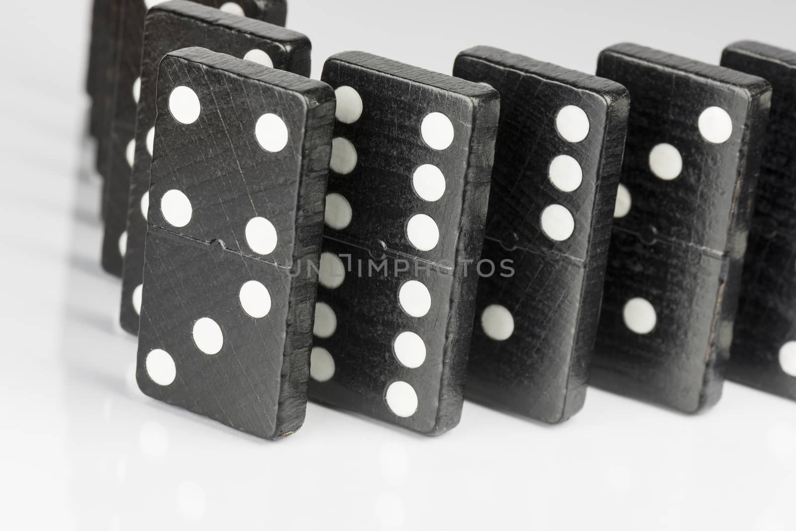 Composition of standing black domino bricks with white dots
