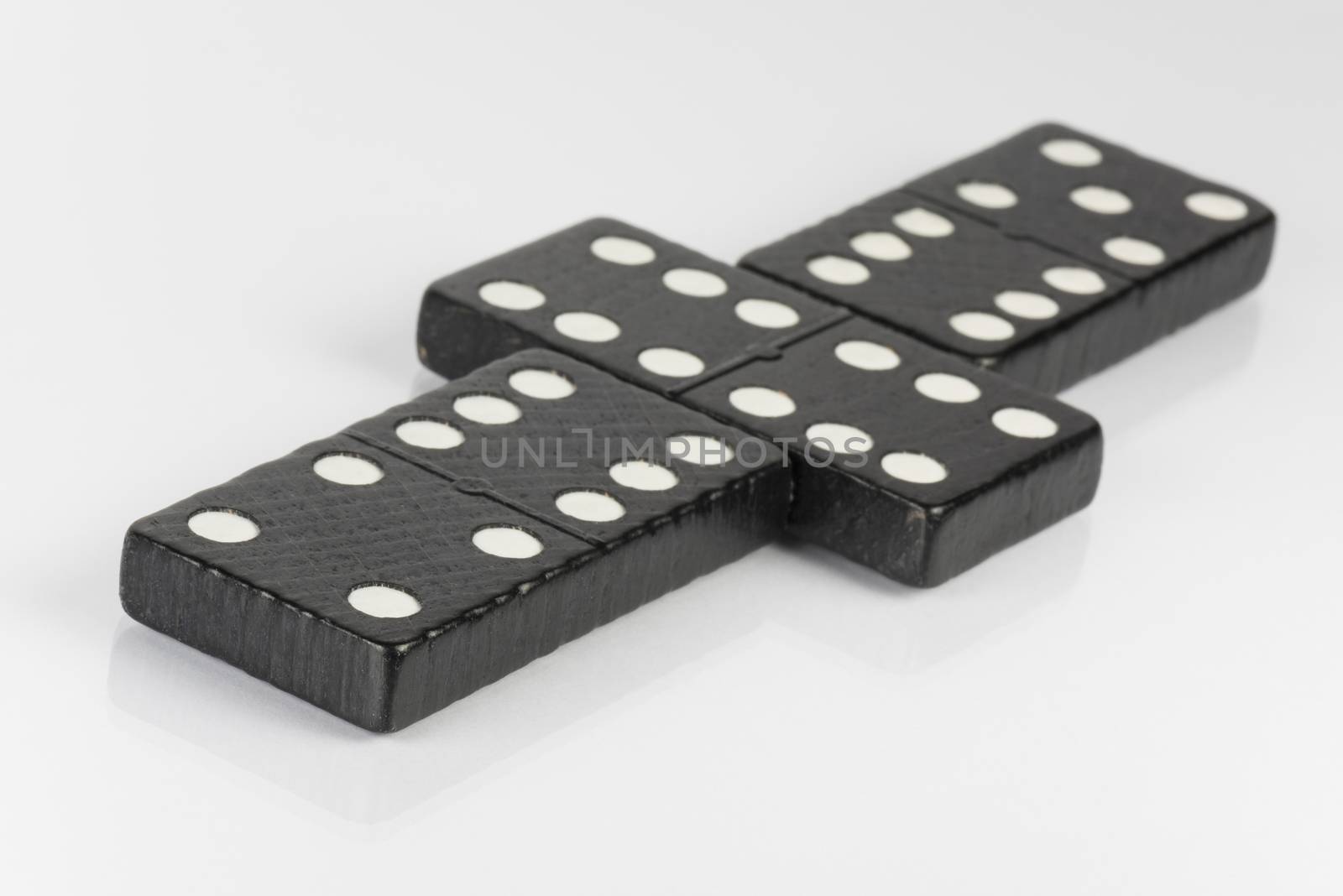 Composition of lying black domino bricks with white dots
