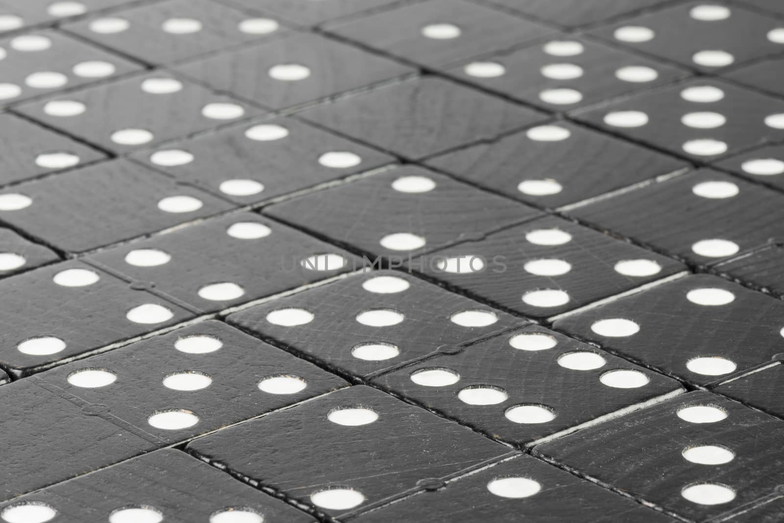 Composition of lying black domino bricks with white dots
