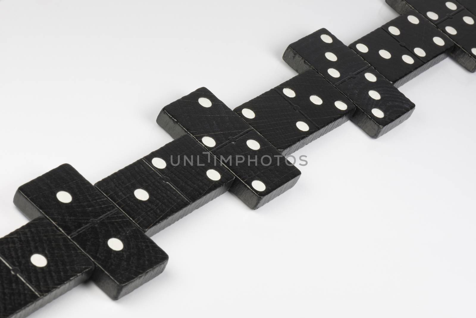 Composition of lying black domino bricks with white dots
