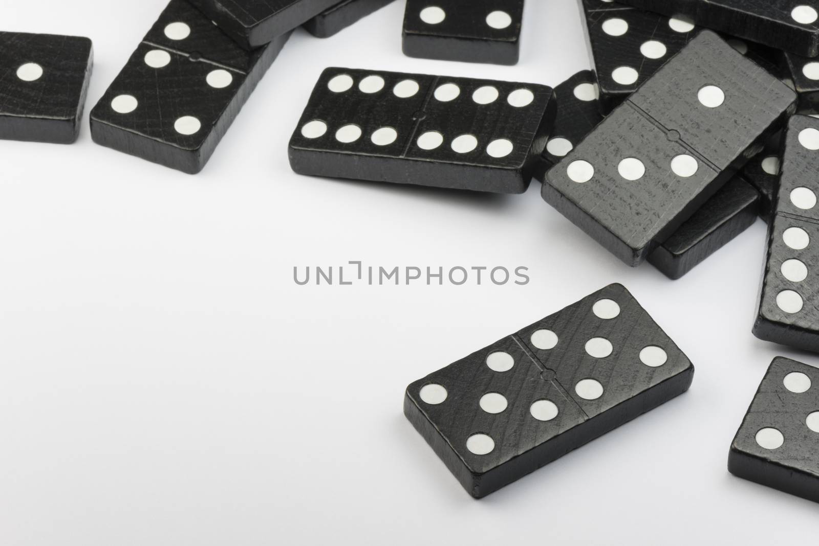 Composition of lying black domino bricks with white dots
