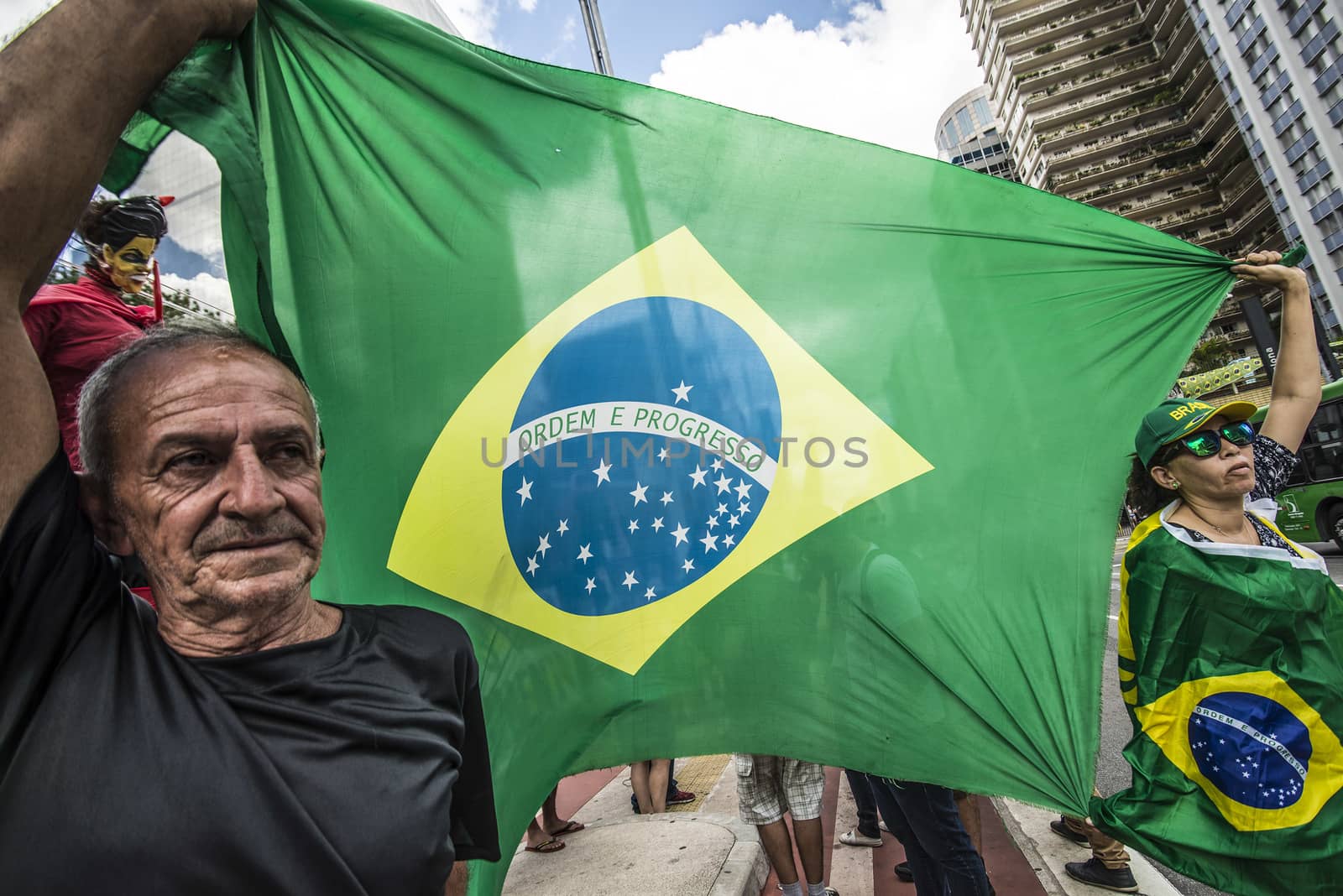 BRAZIL, Sao Paulo: A man and a woman hold a Brazilian flag during a protest for the impeachment of President Dilma Rousseff, against former president Lula and against corruption in Petrobras scandal case in Sao Paulo, Brazil on March 26, 2016. Brazilian lawmakers relaunched impeachment proceedings against President Dilma Rousseff Thursday and a judge blocked her bid to bring her powerful predecessor into her cabinet, intensifying the political crisis engulfing her. 