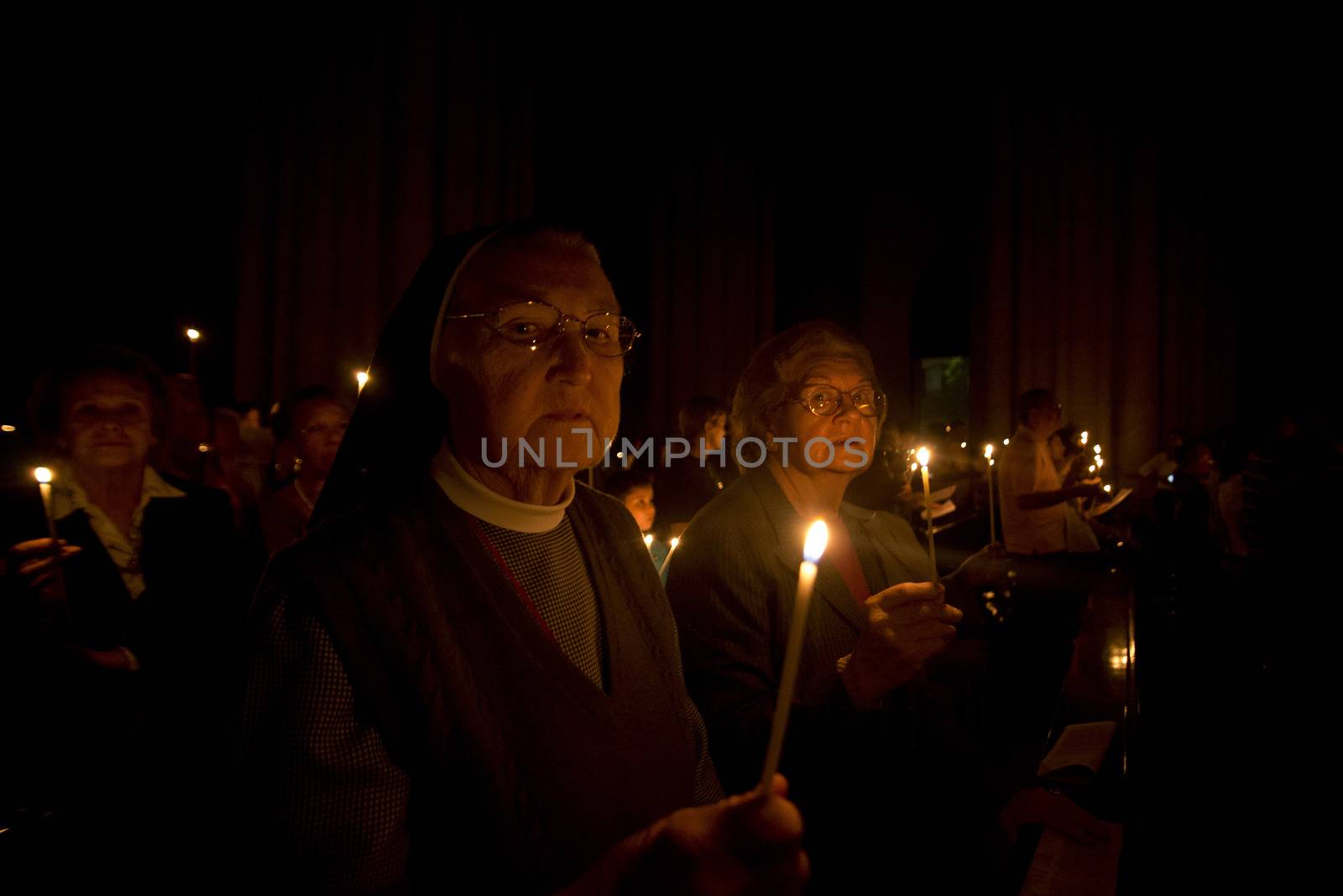 BRAZIL, Sao Paulo: Churchgoers hold candles as they attend Easter mass and vigil at São Paulo See Metropolitan Cathedral on March 26, 2016. Christians around the world are marking the Holy Week, commemorating the crucifixion of Jesus Christ, leading up to his resurrection on Easter.