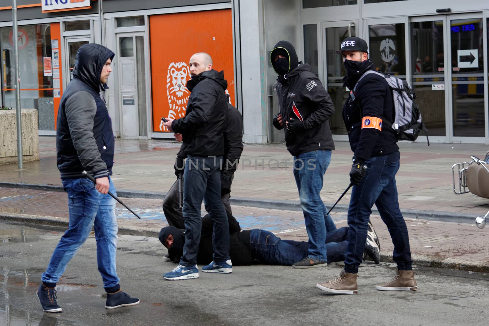 BELGIUM, Brussels: Policemen arrest a man after clash between police and far-right mob at Bourse square in Brussels on March 27, 2016 an area which has become an unofficial shrine to victims of the March 22, terror attacks claimed by the Islamic State (IS) group in which 31 people were killed and over 300 injured. Riot police fired water cannon on March 27, 2016 at far-right football hooligans who invaded a square in the Belgian capital that has become a memorial to the victims of the Brussels attacks. Police took action after about 200 black-clad hooligans shouting nationalist and anti-immigrant slogans moved in on the Place de la Bourse where people were gathering in a show of solidarity with the victims.