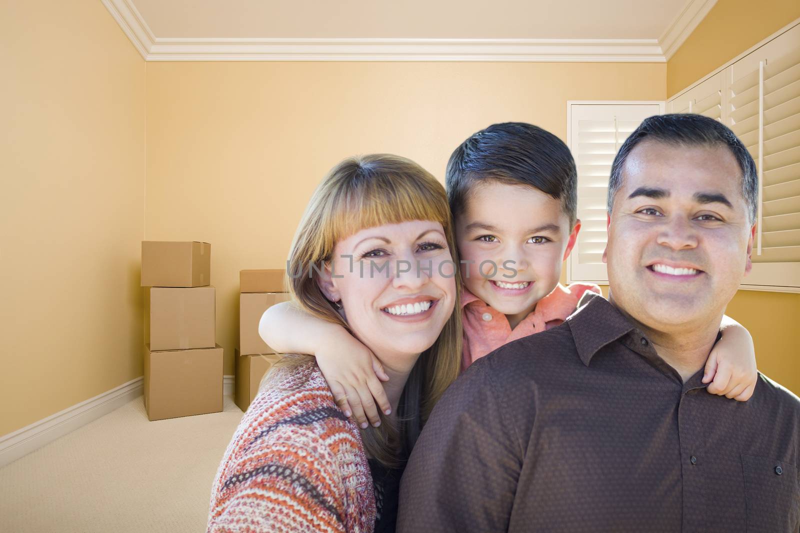 Happy Young Mixed Race Family In Room With Moving Boxes.