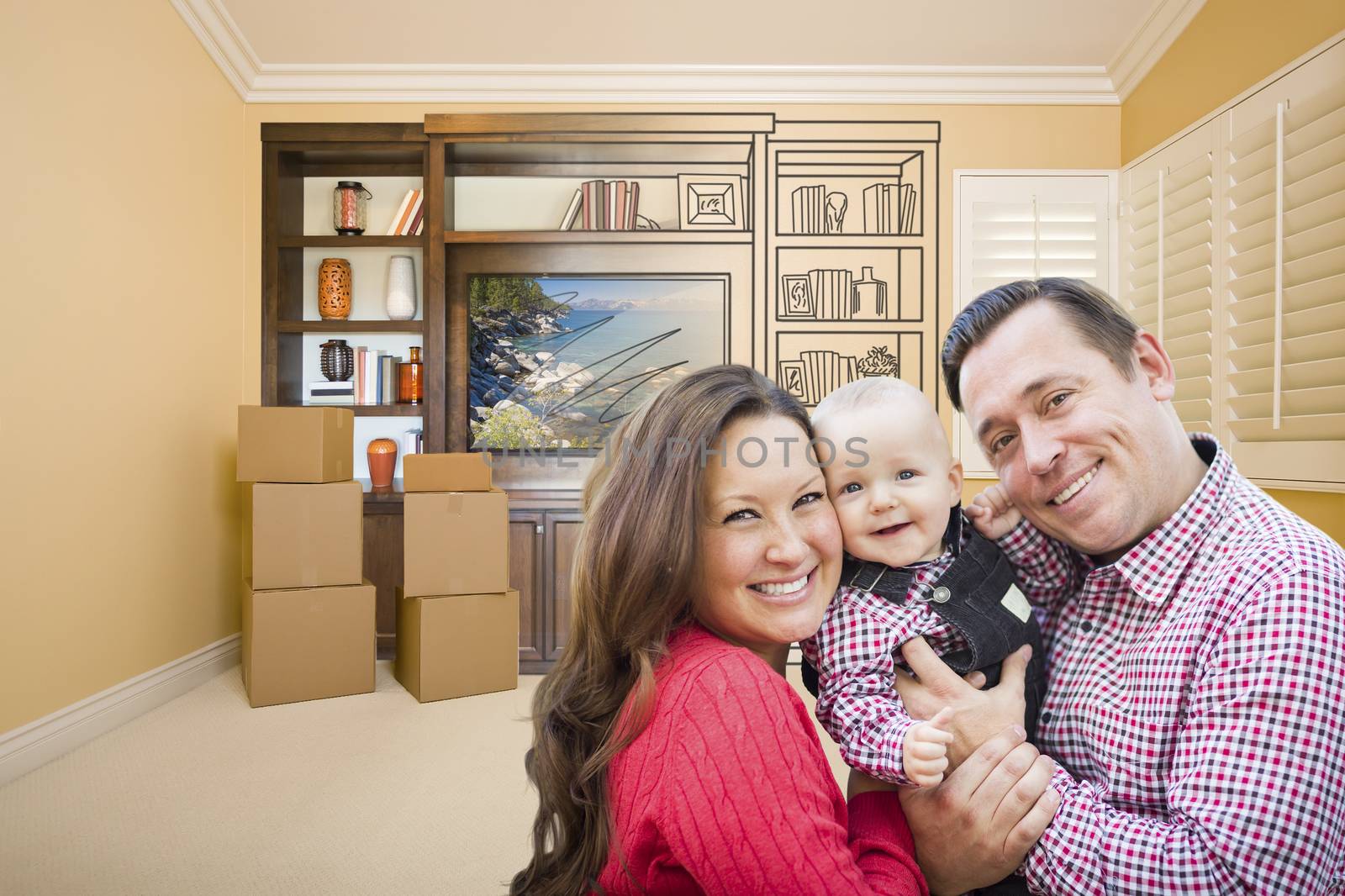 Young Family In Room With Moving Boxes and Drawing of Entertainment Unit On Wall.