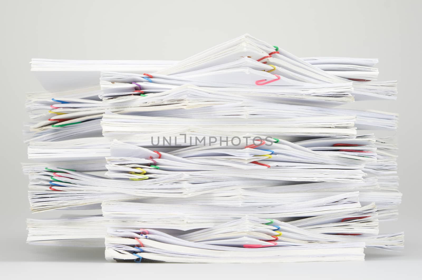 Overload document of report and receipt with colorful paperclip on white table.