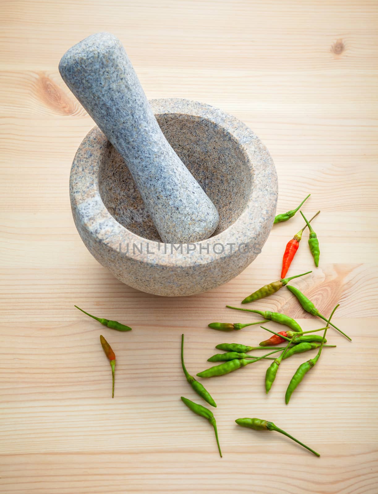 Fresh Chillies on white wooden background with mortar and pestle. Selective focus depth of field.