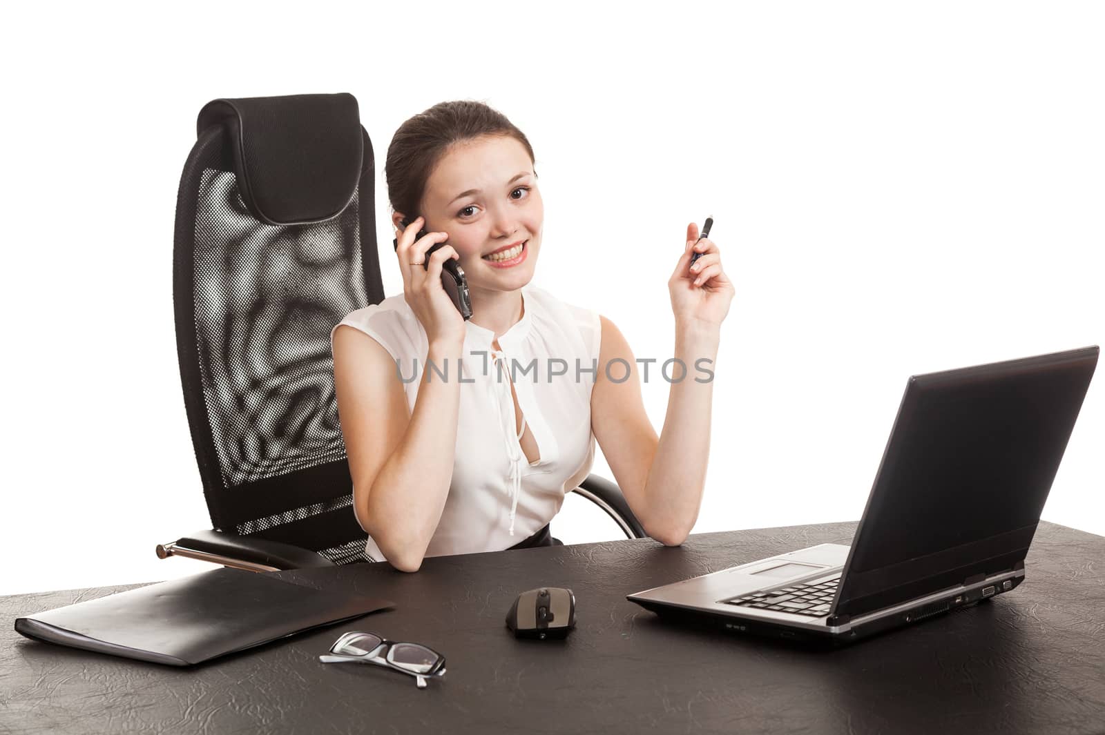 the business woman sits at office table with the laptop and speaks by phone