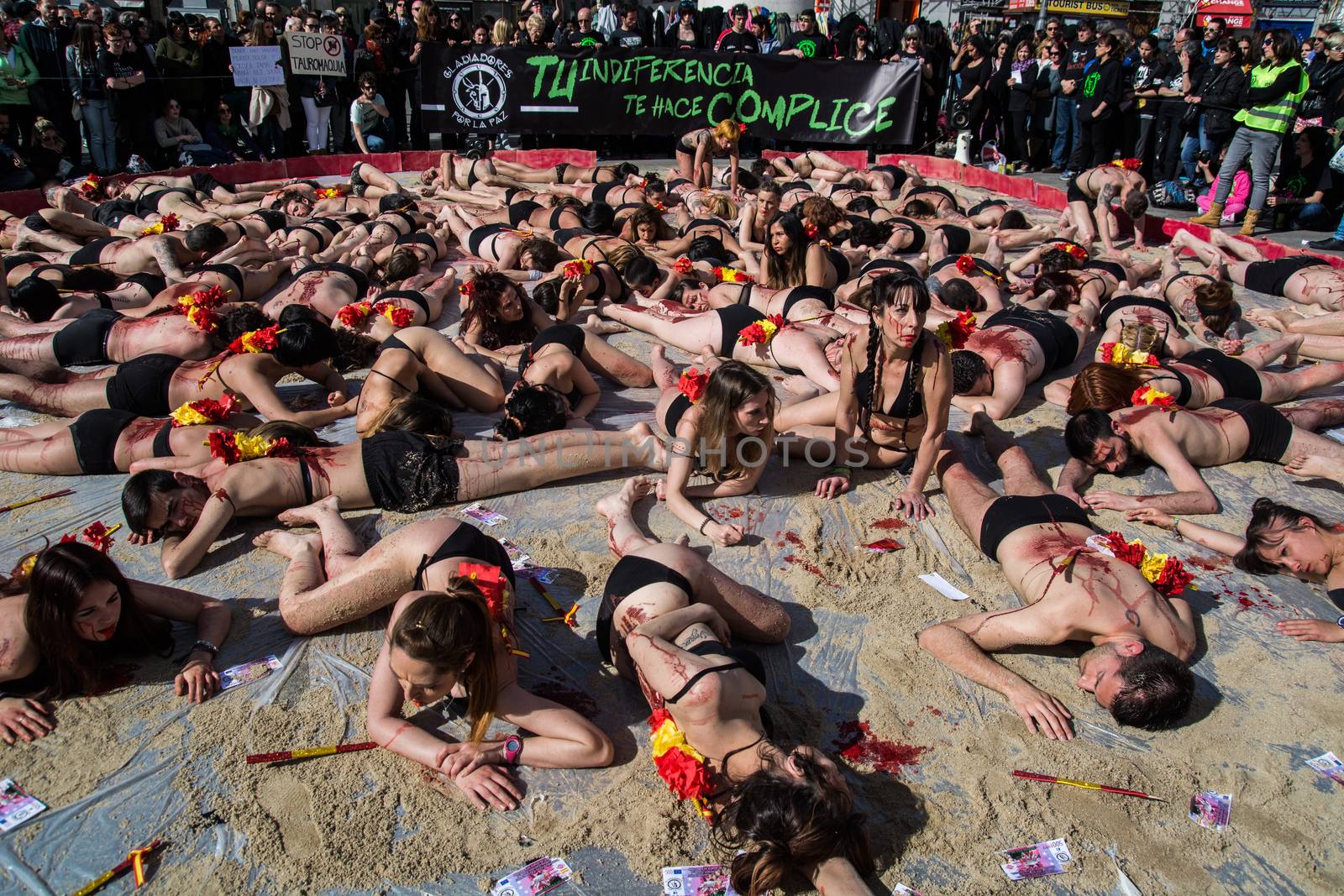 SPAIN, Madrid: Anti-bullfighting protesters covered with red paint as if it is blood gather at Puerta del Sol square, in Madrid, on March 27, 2016 against bullfights. They have turned the iconic square of Puerta del Sol into a bullring. Protesters demand the abolition of bullfights under the slogan  The bull suffers!