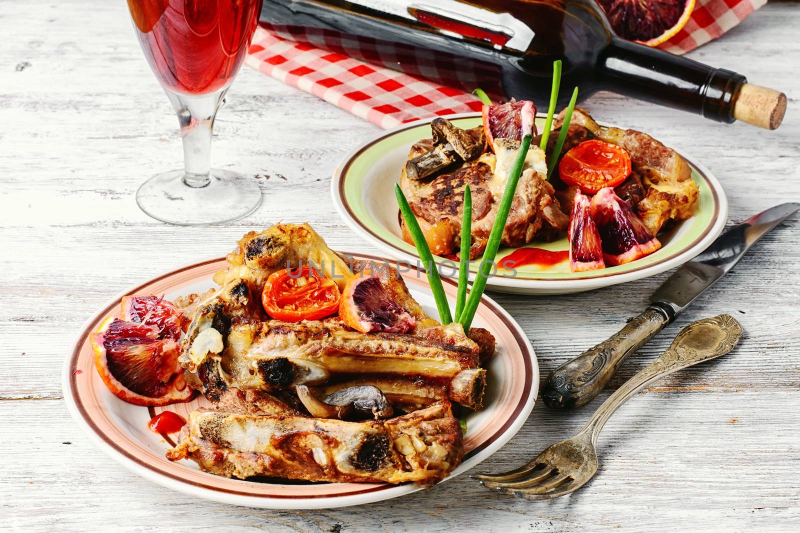 Portion of baked beef on the bone and a glass of red wine