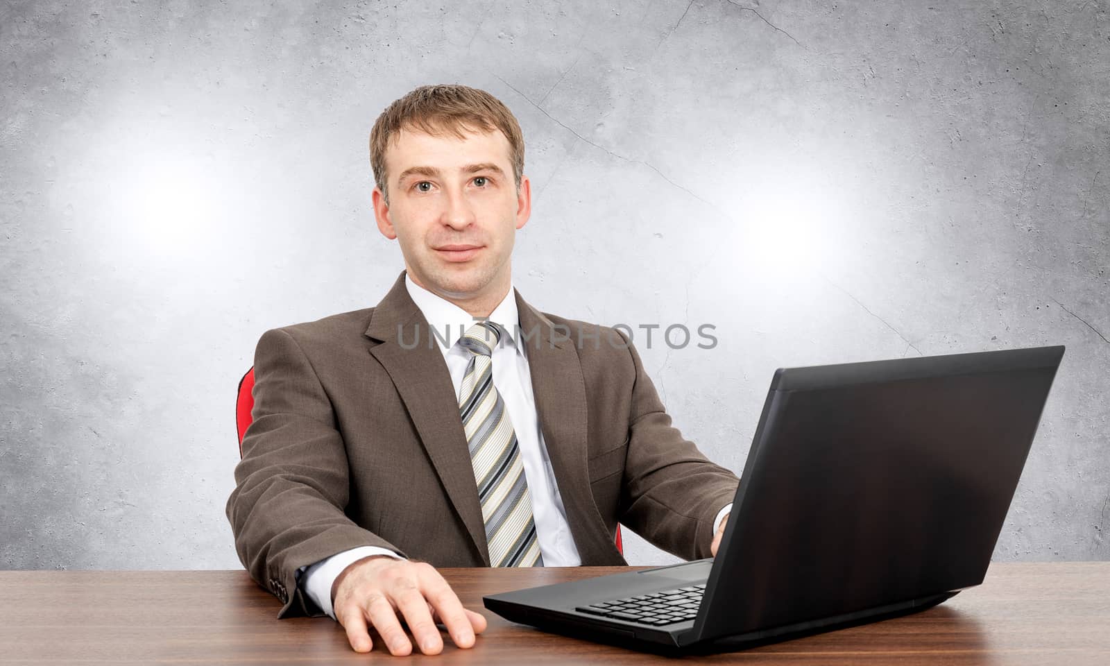 Businessman with laptop looking at camera, business concept