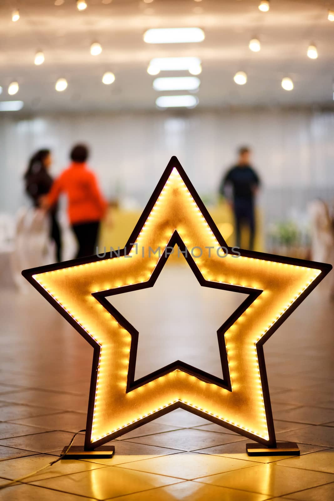 Decorative star made of wood with LED backlight on the floor, preparing for the wedding party.