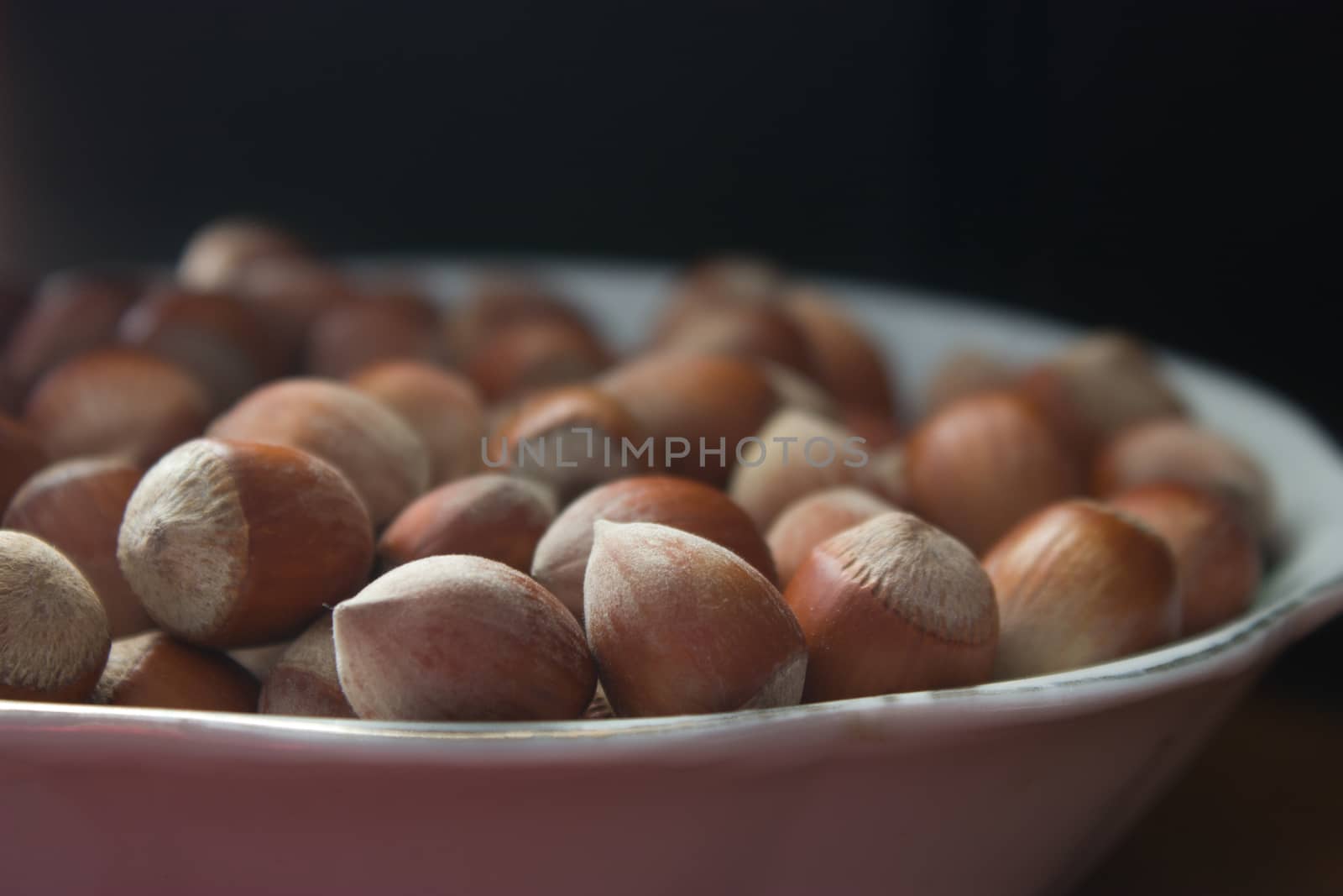 hazelnuts with shells in a plane on wooden table