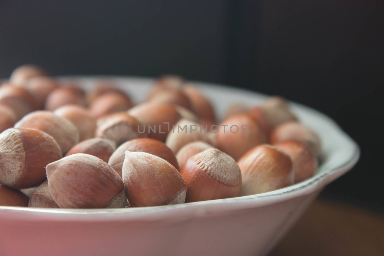 hazelnuts with shells in a plane on wooden table