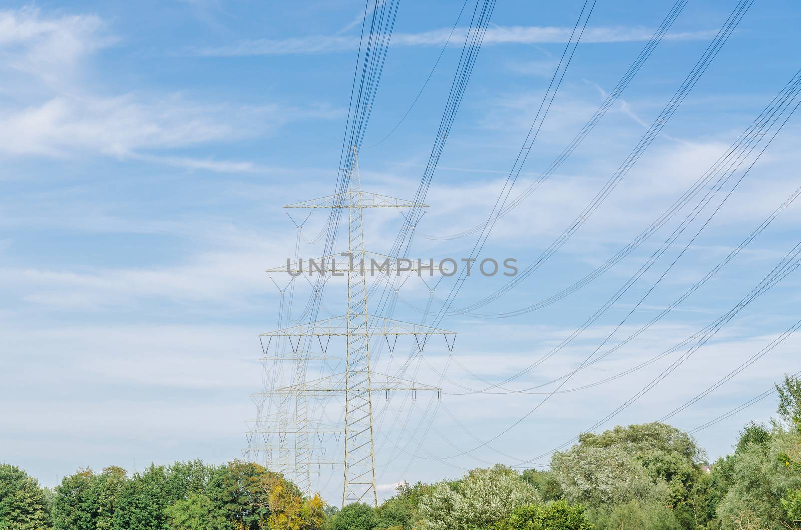 High voltage towers with blue sky in the background.