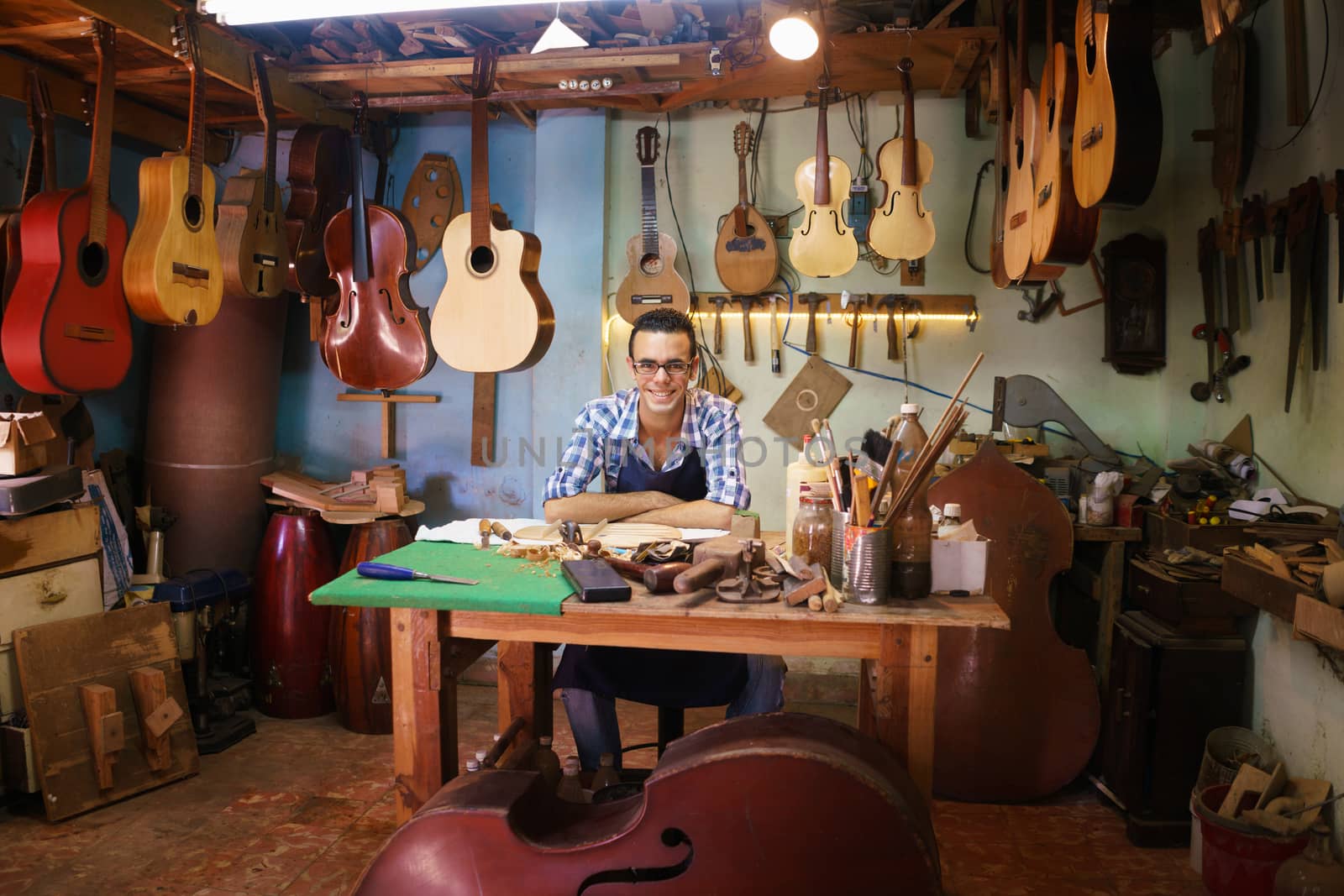 Portrait Of Happy Artisan Lute Maker In Guitar Shop Smiling At C by diego_cervo