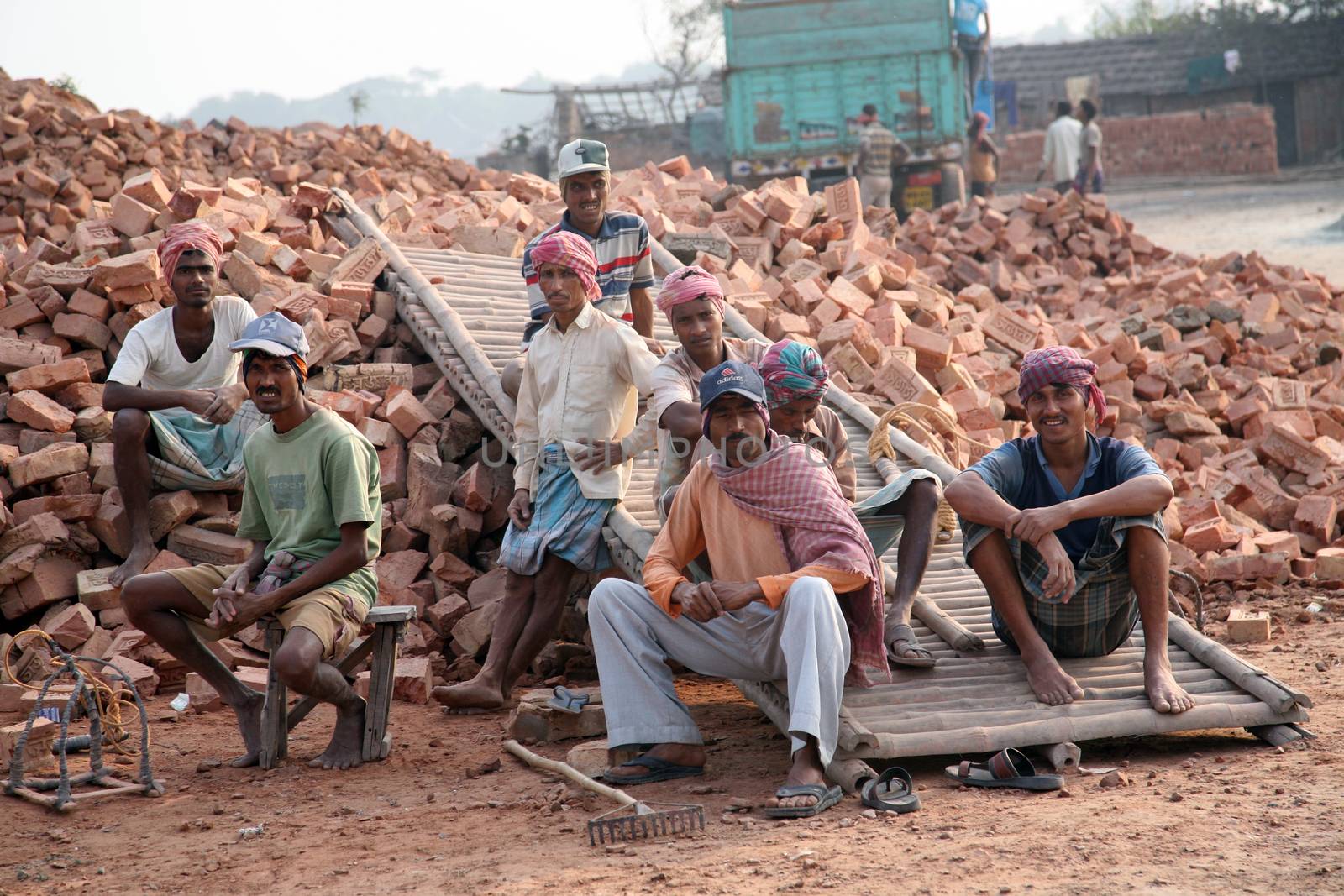 Brick field workers rest after hard work, wearing just baked brick from the kiln in truck on January 16, 2009 in Sarberia, West Bengal, India.
