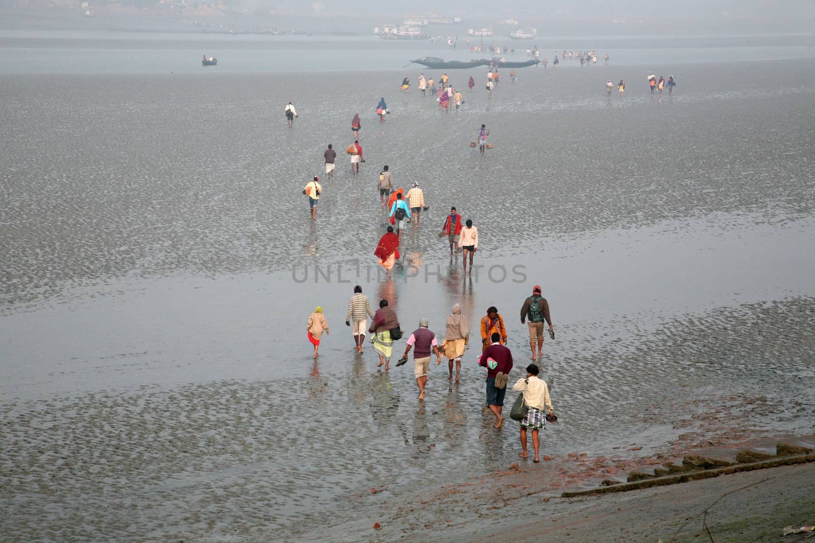 During low tide the water in the river Malta falls so low that people walk to the other shore in Canning Town, India