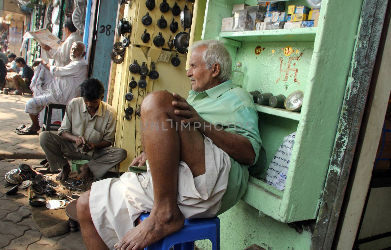 Indian man outside a shop selling car parts on Malik bazar in Kolkata, India