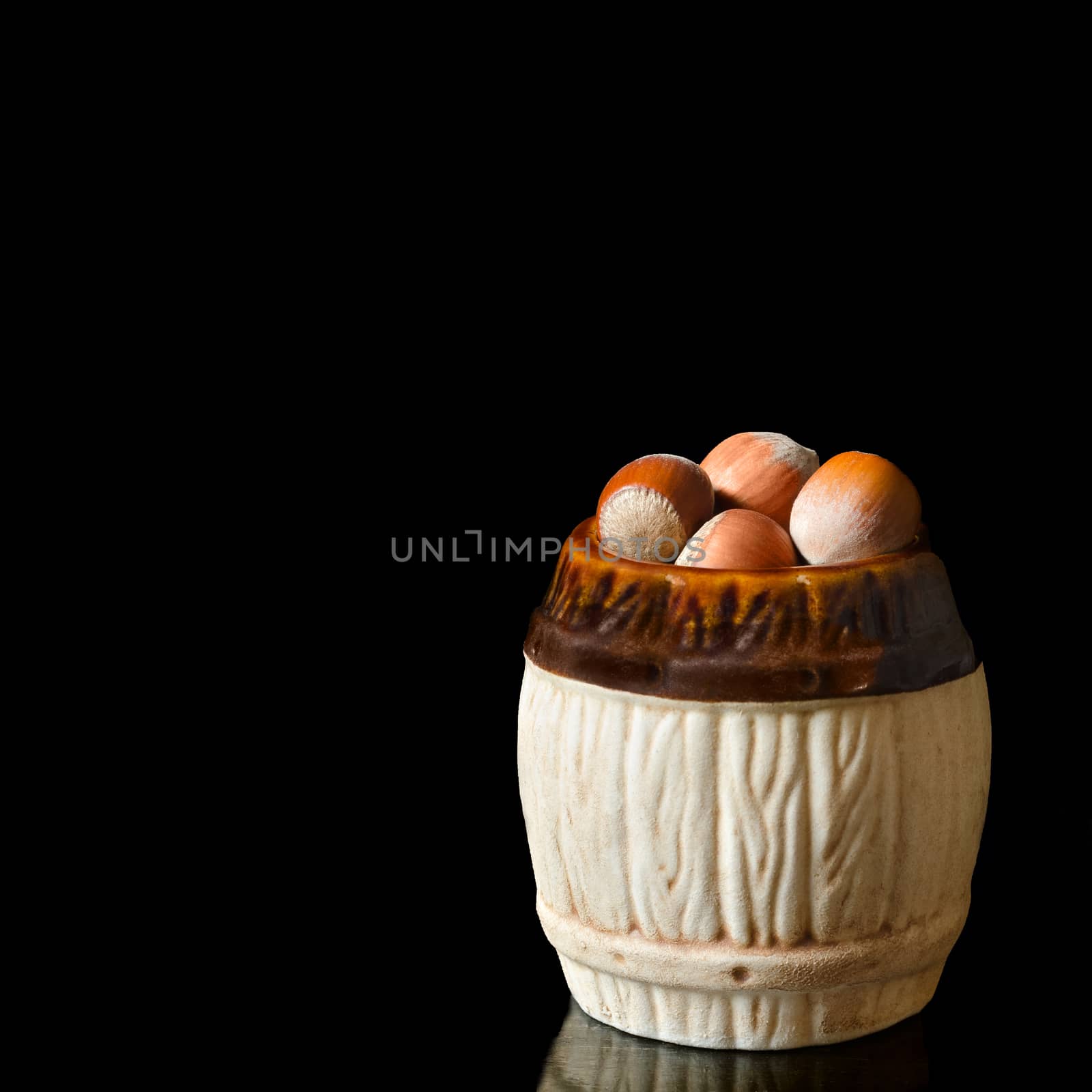 Hazelnuts on a black background,in a ceramic dish.