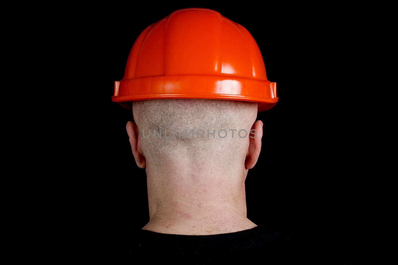 Construction worker in orange protective helmet on a gray background