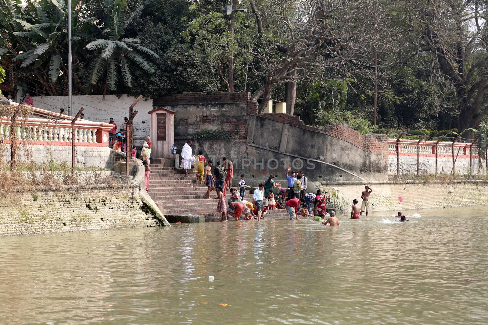 Hindu people bathing in the ghat near the Dakshineswar Kali Temple in Kolkata, West Bengal, India