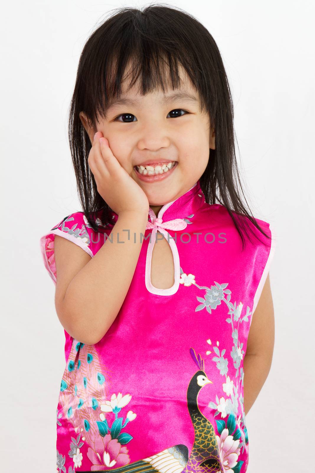 Chinese Little Girl wearing Cheongsam with greeting gesture in plain white background.