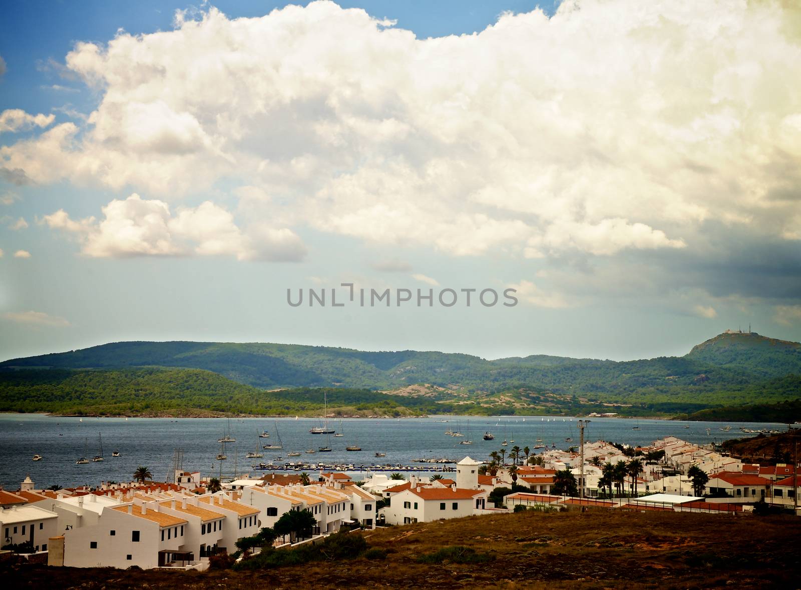 Small Menorca Urbanization Fornells between Hills and near Yacht Marina under Cloudy Skies Outdoors. Balearic Islands