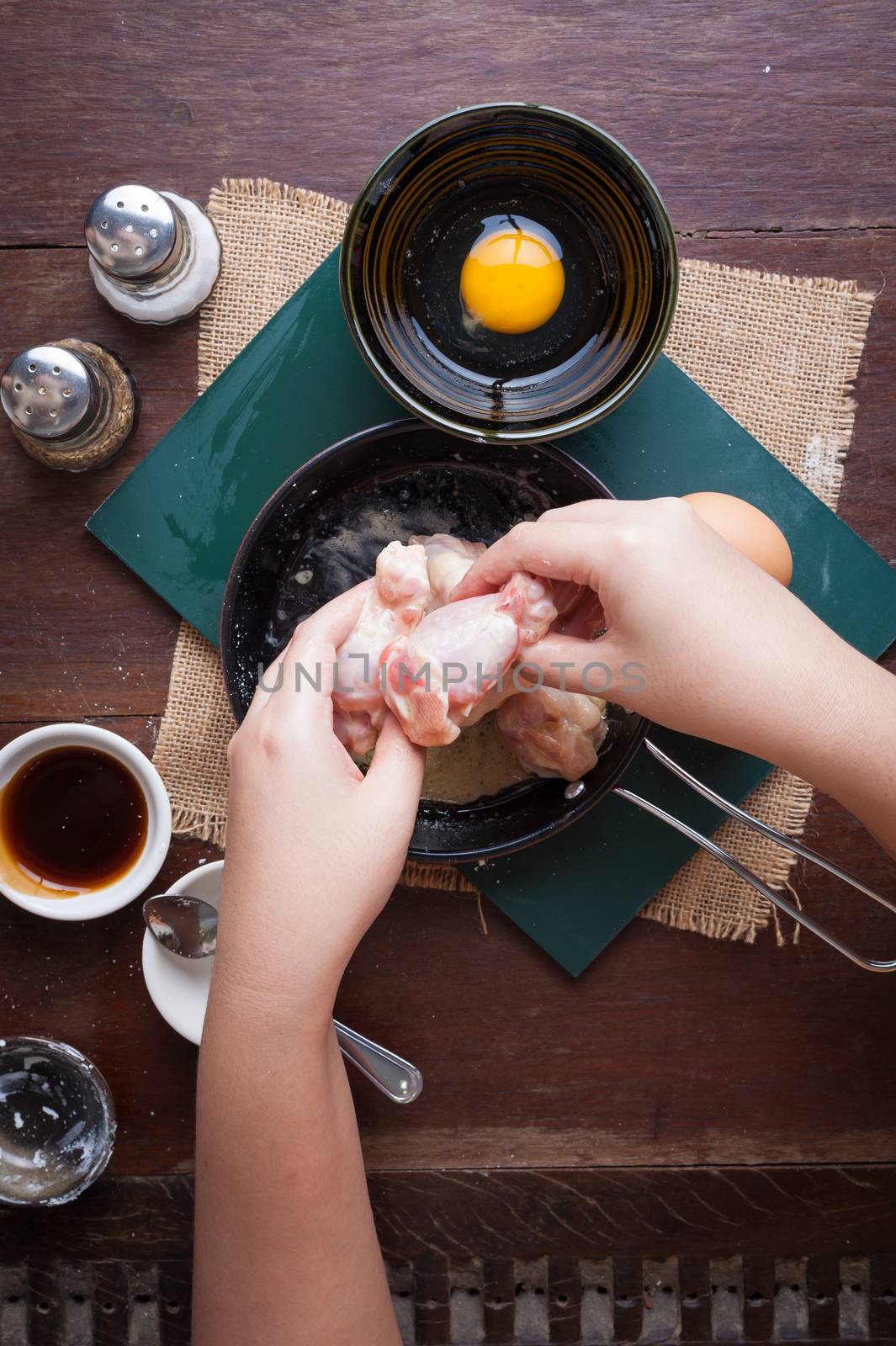 Preparation for cooking in home kitchen. Woman hand mixing ingredients with chicken wings