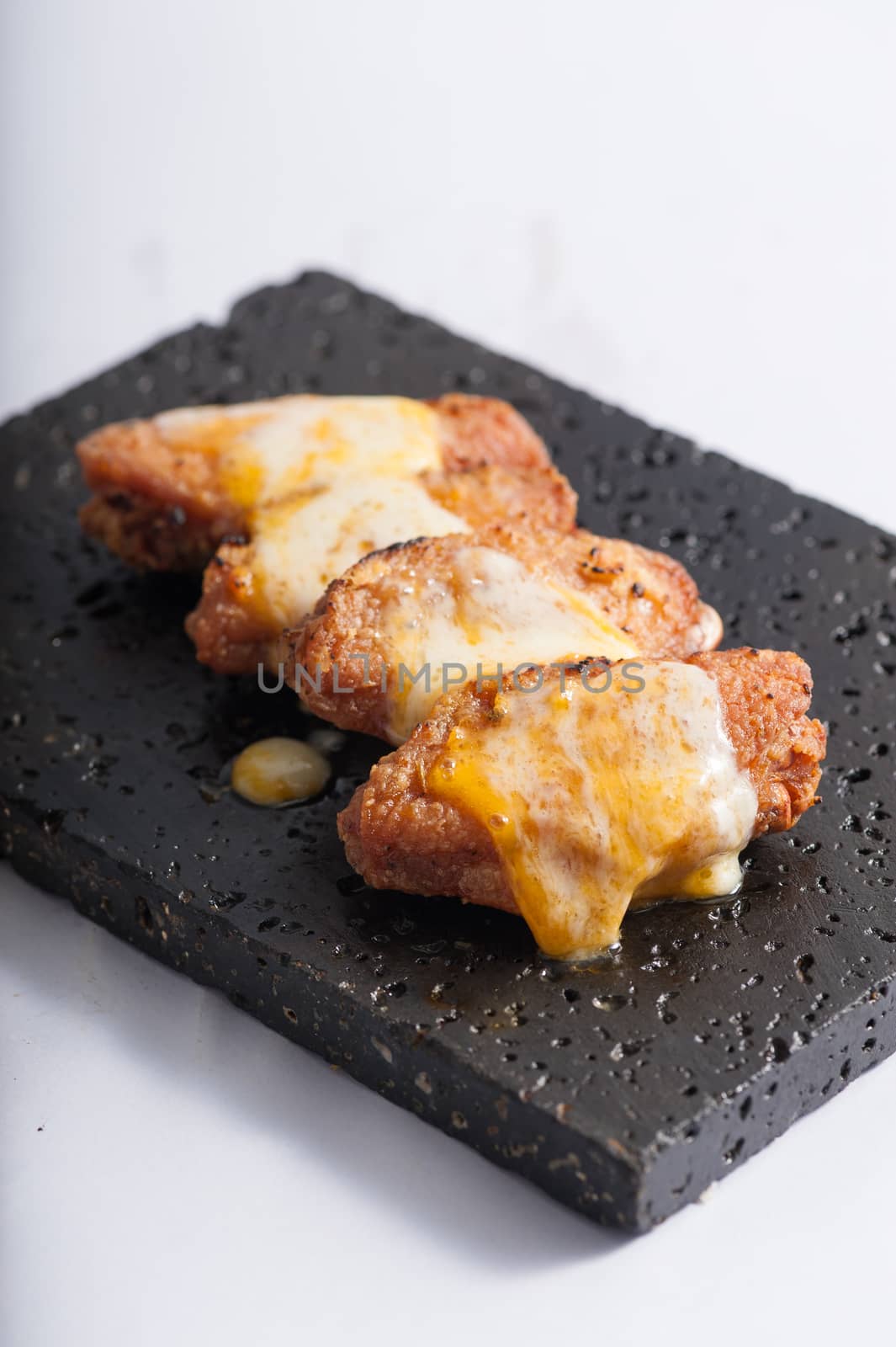 Deep fried chicken wings dressed with various types of cheese