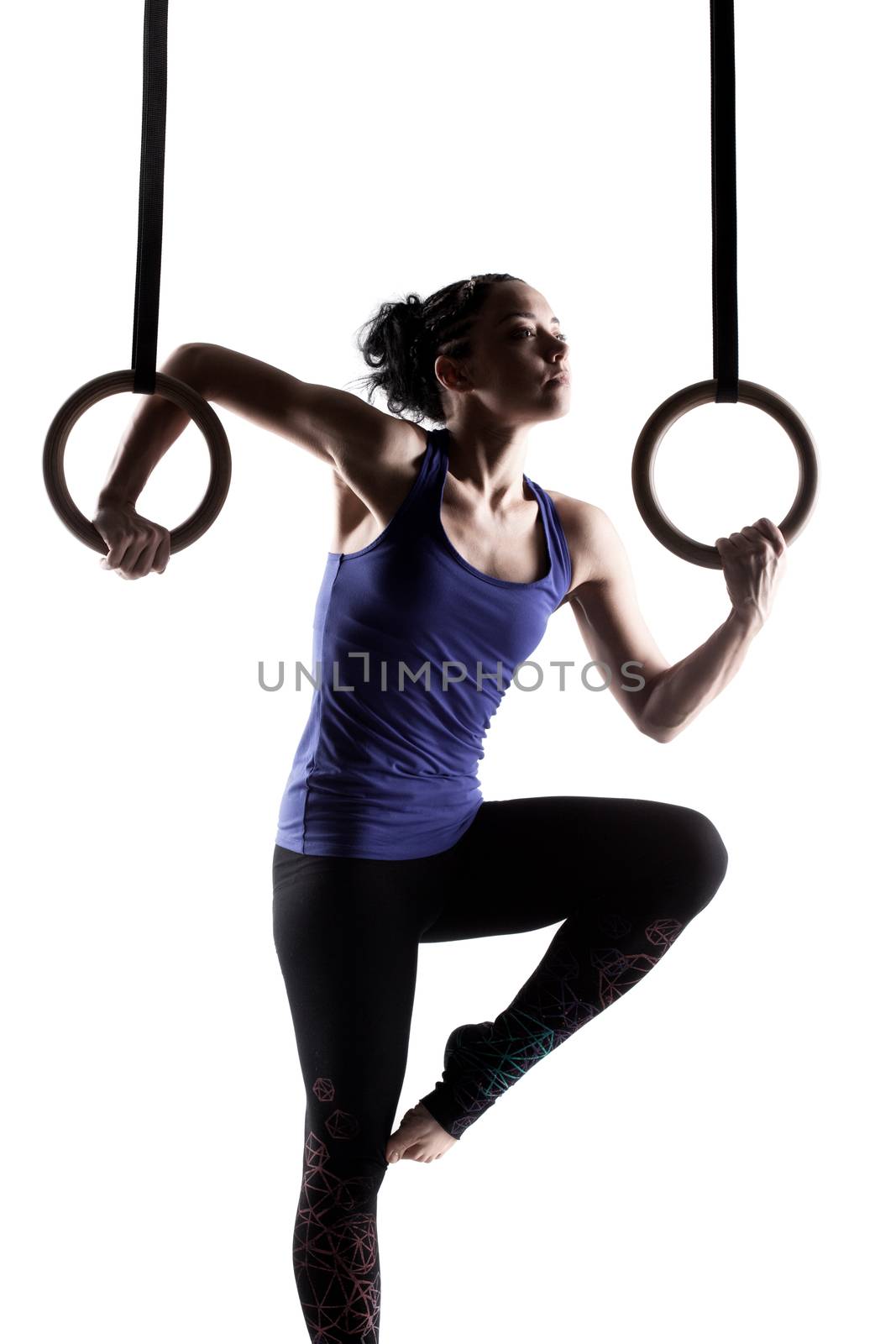 fit girl girl exercising on gymnast rings, against white background