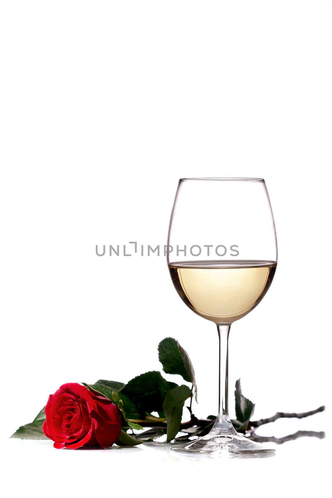 red rose next to a glass of white wine