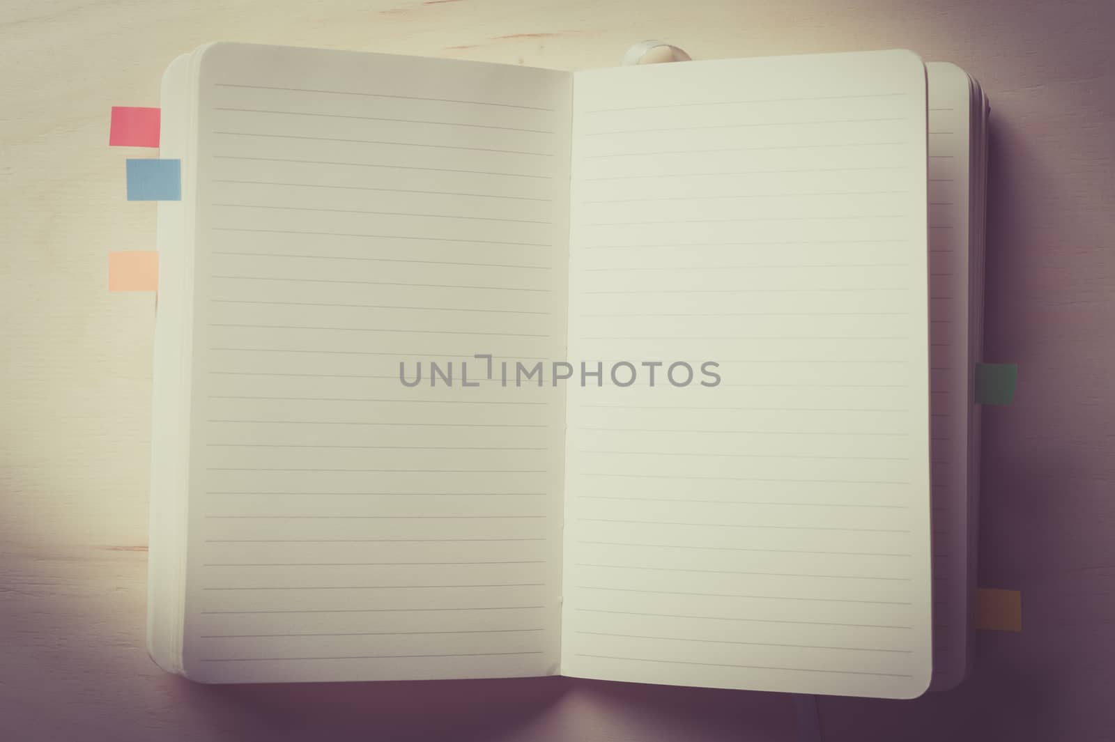 Opened notebook with blank area for text or message on wood table with vintage filter effect