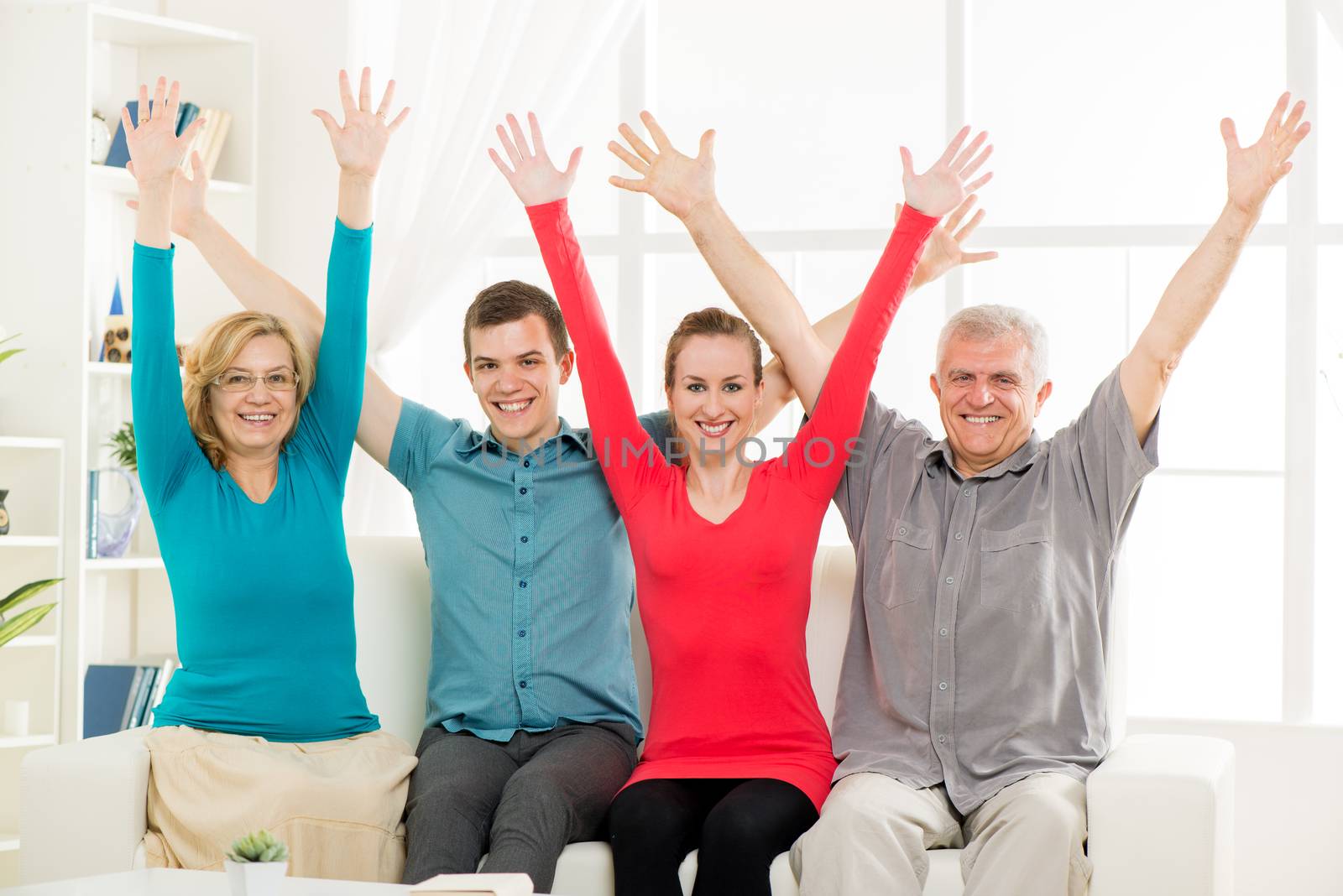 Cheerful family enjoying at home and rejoices with open arms 